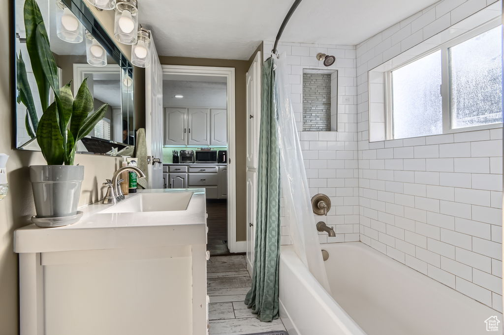 Bathroom featuring shower / bath combo, vanity, and wood finished floors