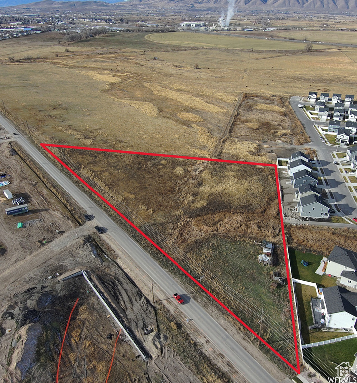 Aerial view of residential area with property boundaries highlighted and mountains