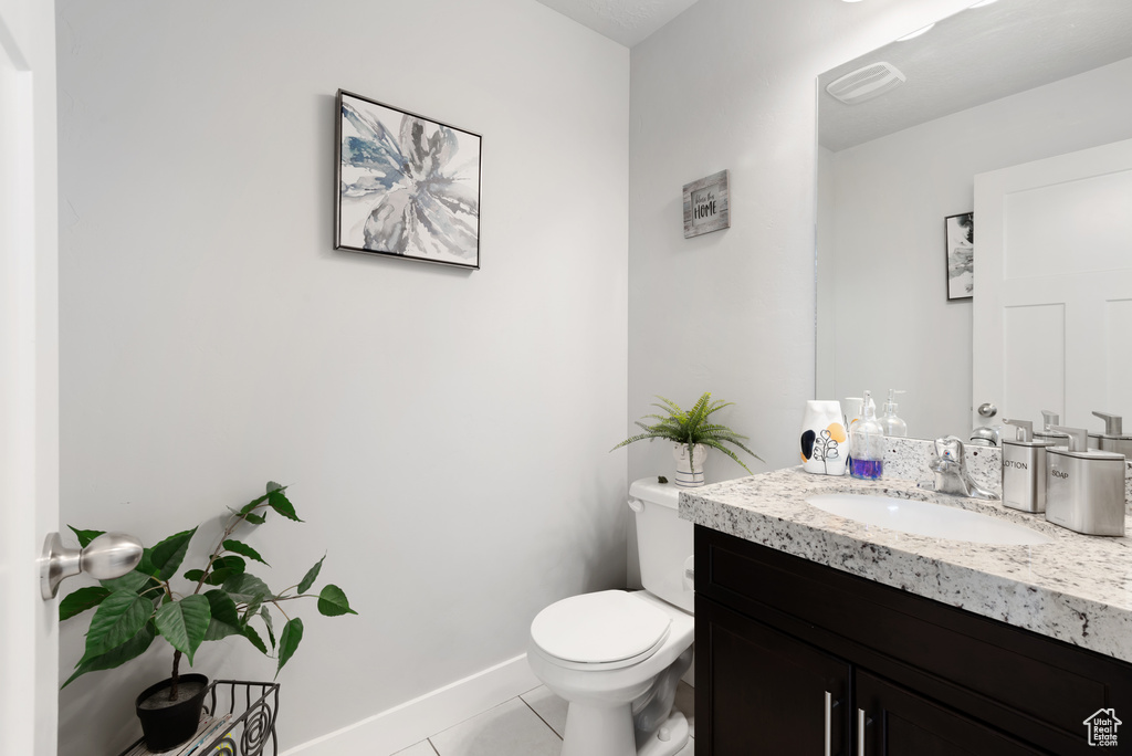 Bathroom with tile patterned flooring, toilet, vanity, and baseboards