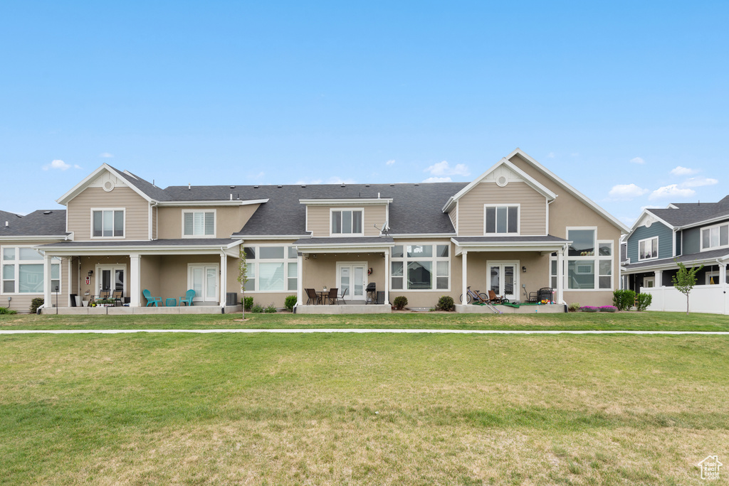 Townhome / multi-family property with french doors, a patio area, and a shingled roof