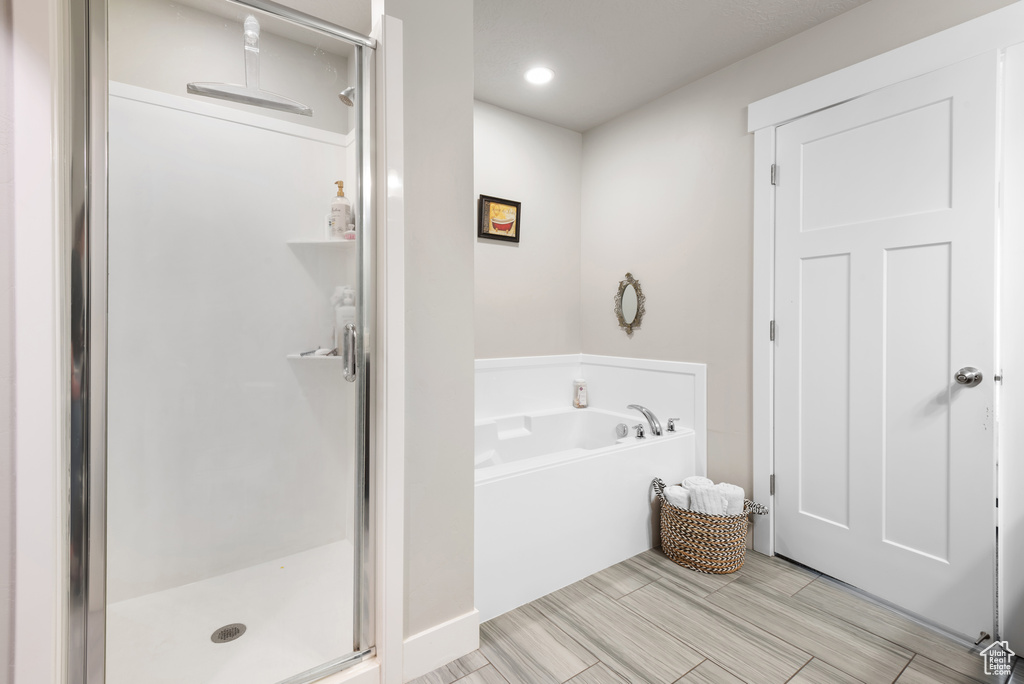 Full bath with a stall shower, a garden tub, and recessed lighting