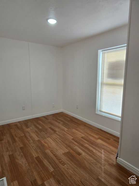 Unfurnished room featuring dark wood finished floors, baseboards, and recessed lighting