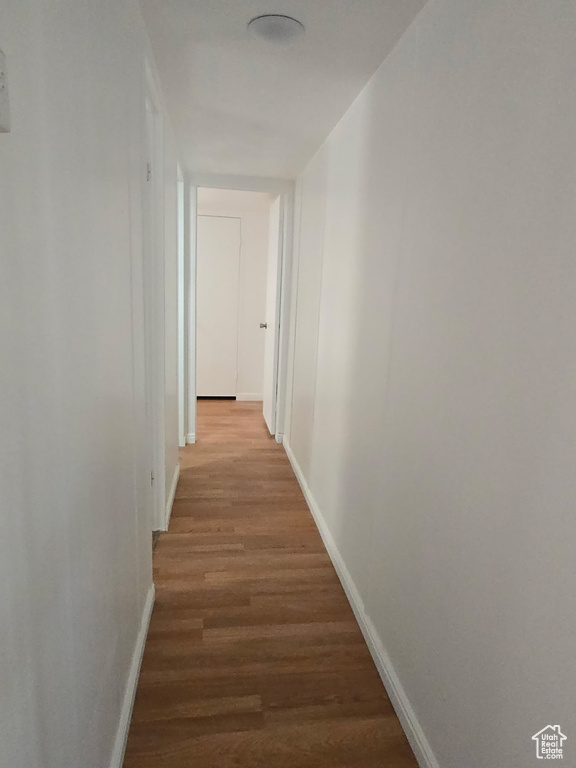 Hall with baseboards and wood finished floors