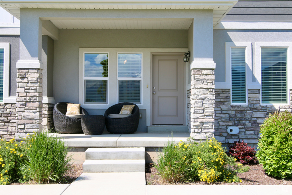 Doorway to property featuring stone siding and stucco siding