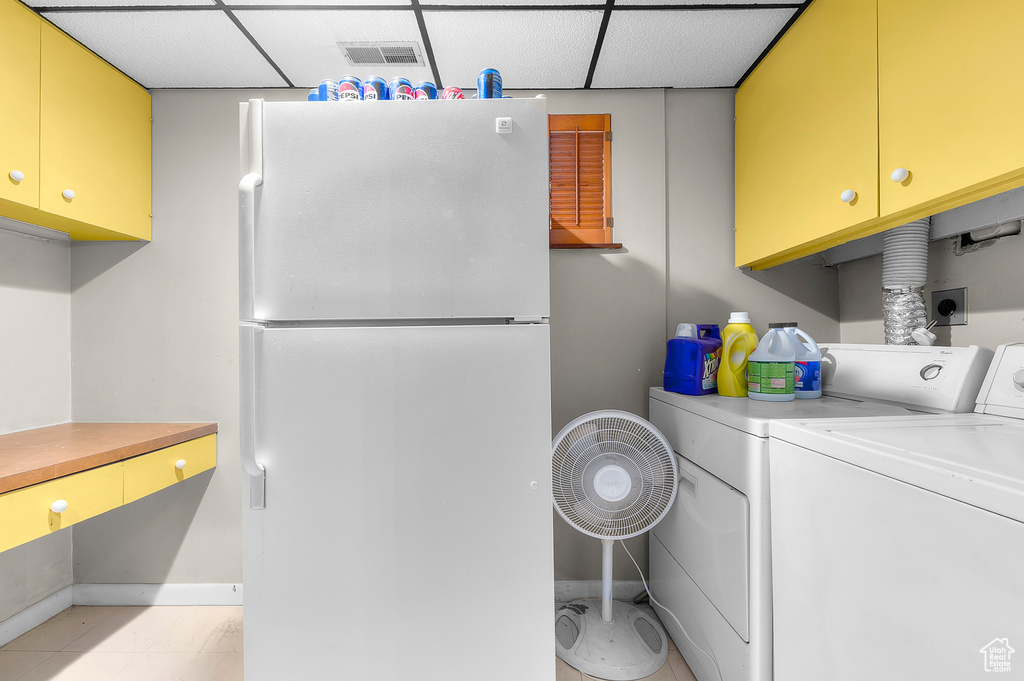 Laundry room featuring washing machine and dryer, baseboards, and cabinet space