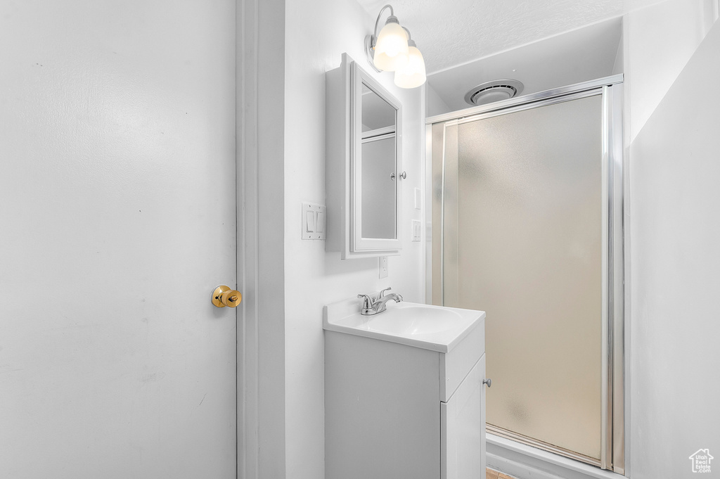 Bathroom featuring a shower stall and vanity