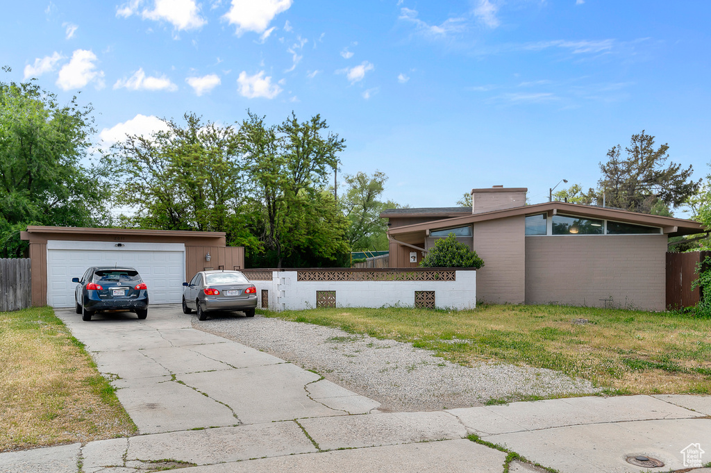 View of front of home featuring concrete driveway and a chimney