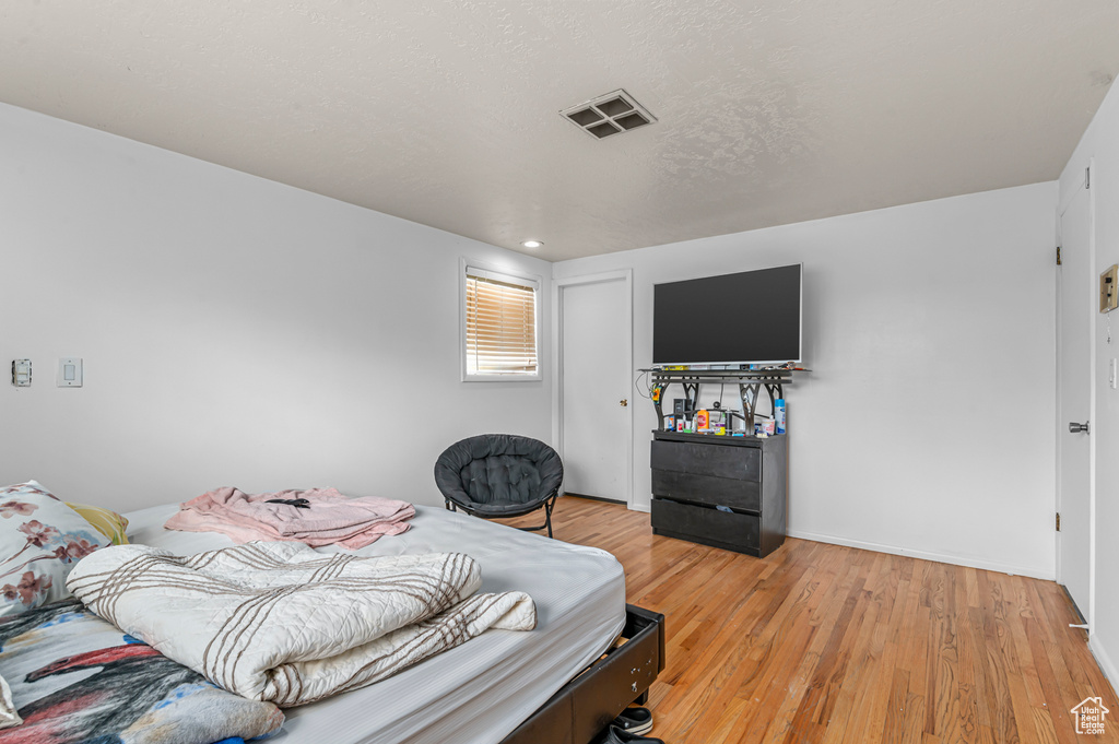 Bedroom with light wood-style floors, baseboards, and recessed lighting