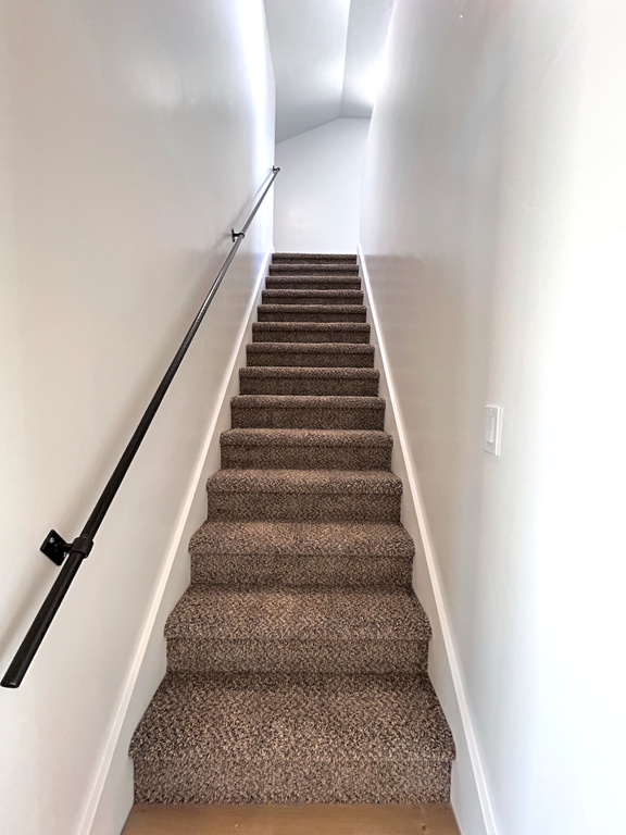Stairway featuring vaulted ceiling