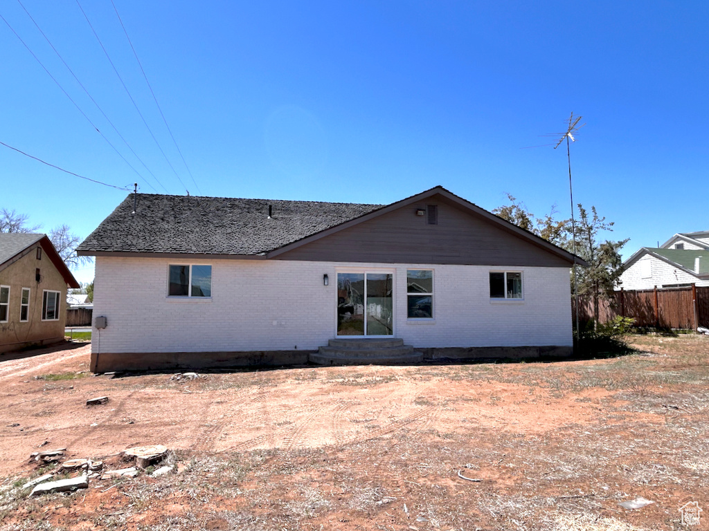 Rear view of house featuring entry steps and brick siding