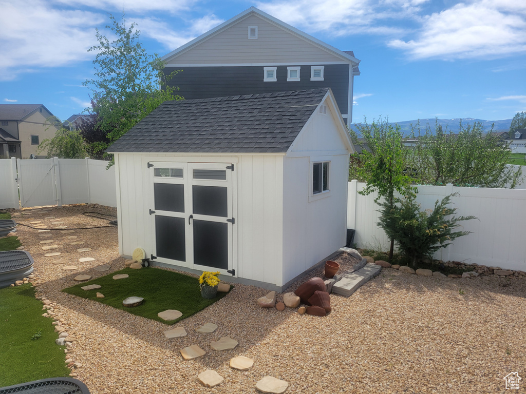 View of shed featuring a mountain view, a fenced backyard, and a gate