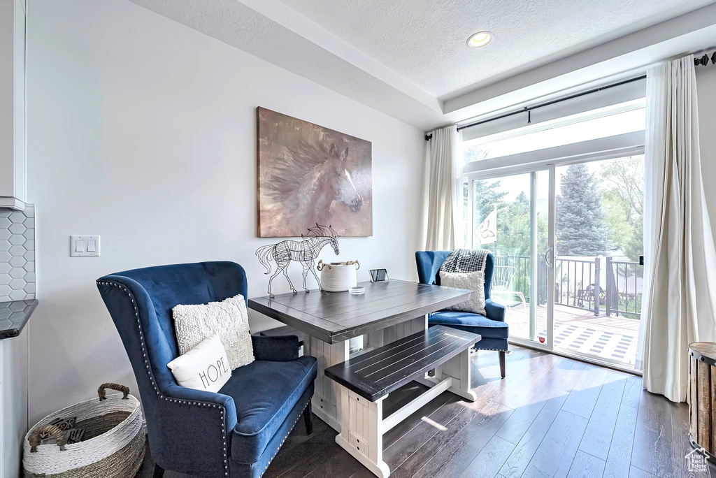 Dining room featuring hardwood / wood-style flooring, a textured ceiling, a tray ceiling, and recessed lighting