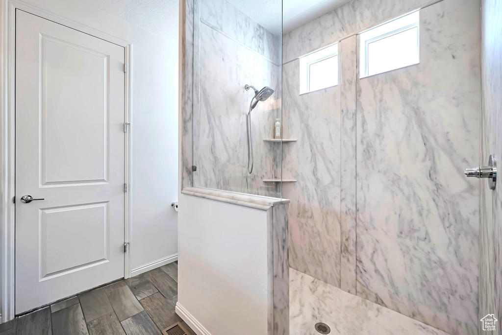 Bathroom featuring a marble finish shower and baseboards