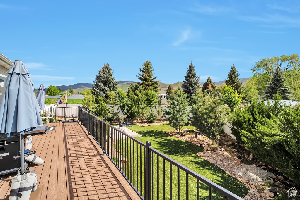 Deck with a mountain view and a yard
