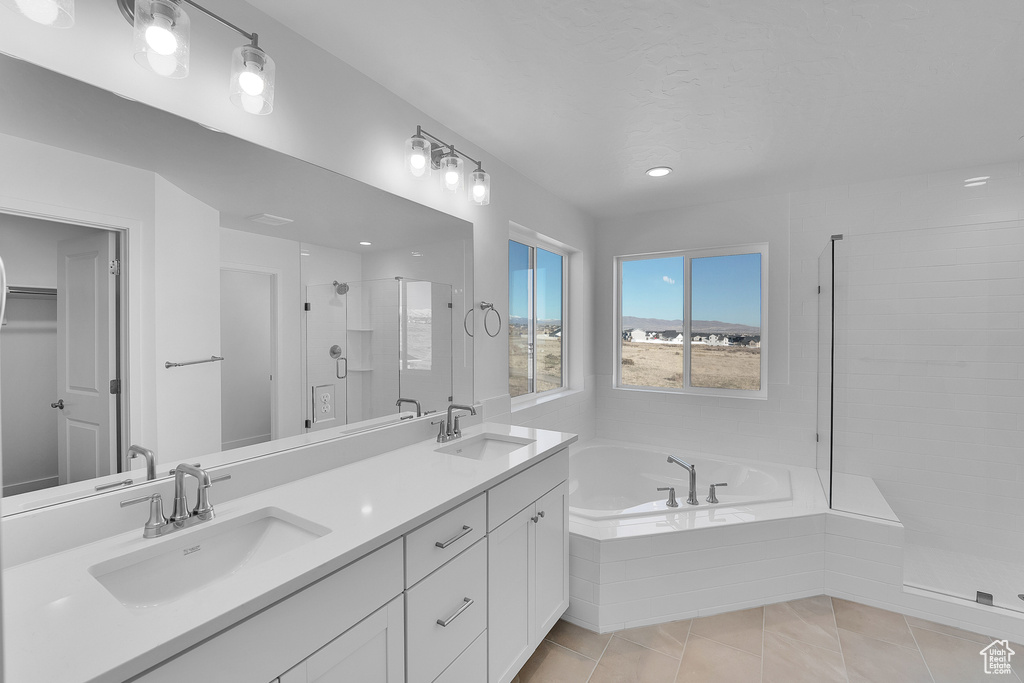 Bathroom featuring a shower stall, a bath, double vanity, tile patterned floors, and recessed lighting