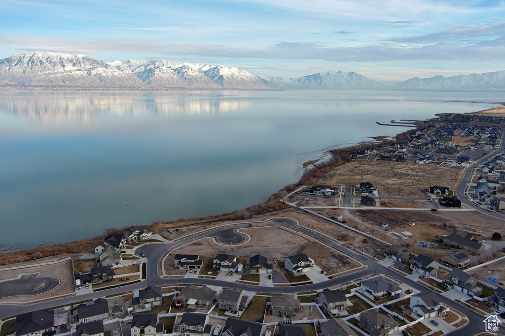 Aerial view of property and surrounding area with a water and mountain view and nearby suburban area