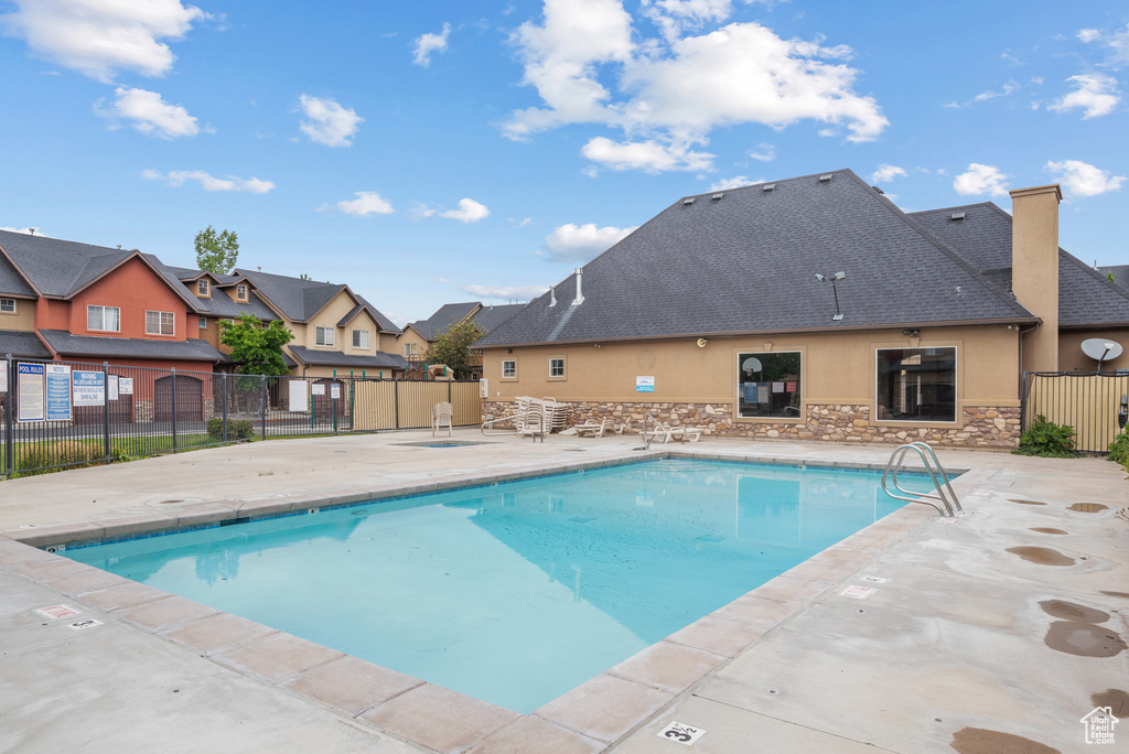 Community pool featuring a patio area and a residential view