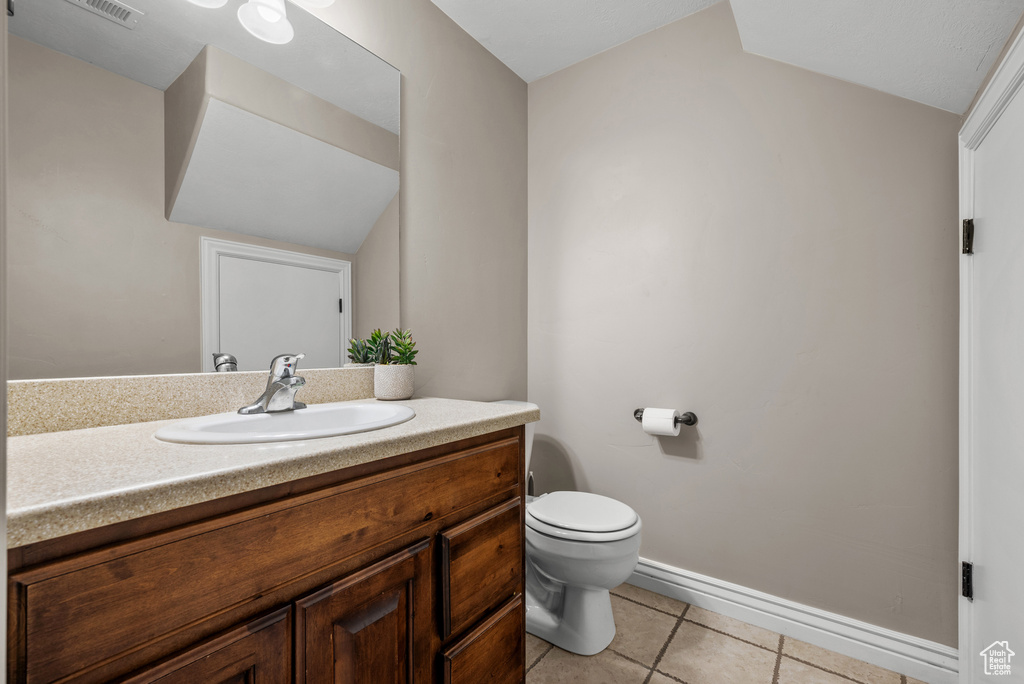 Bathroom featuring tile patterned floors, toilet, vanity, and baseboards
