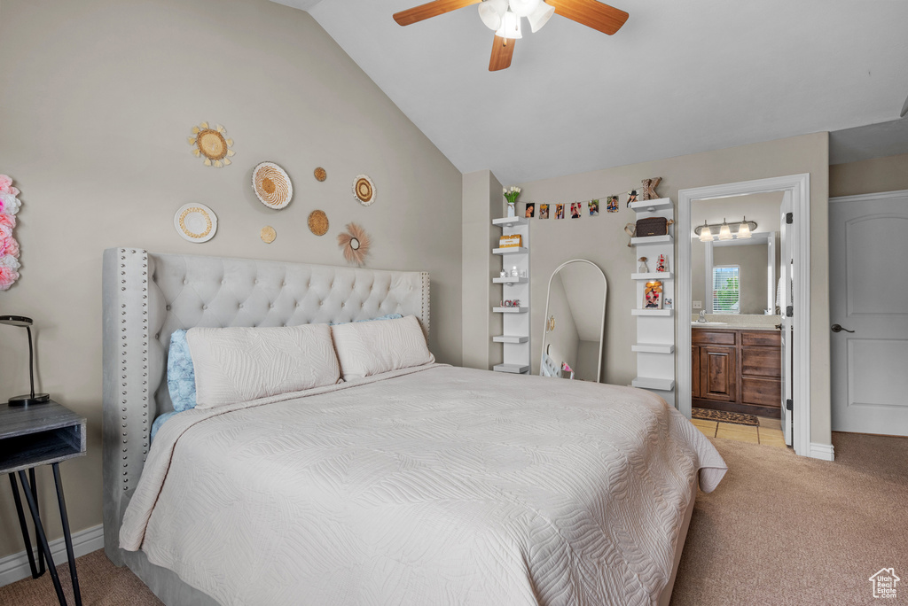 Bedroom featuring light colored carpet, lofted ceiling, connected bathroom, ceiling fan, and baseboards