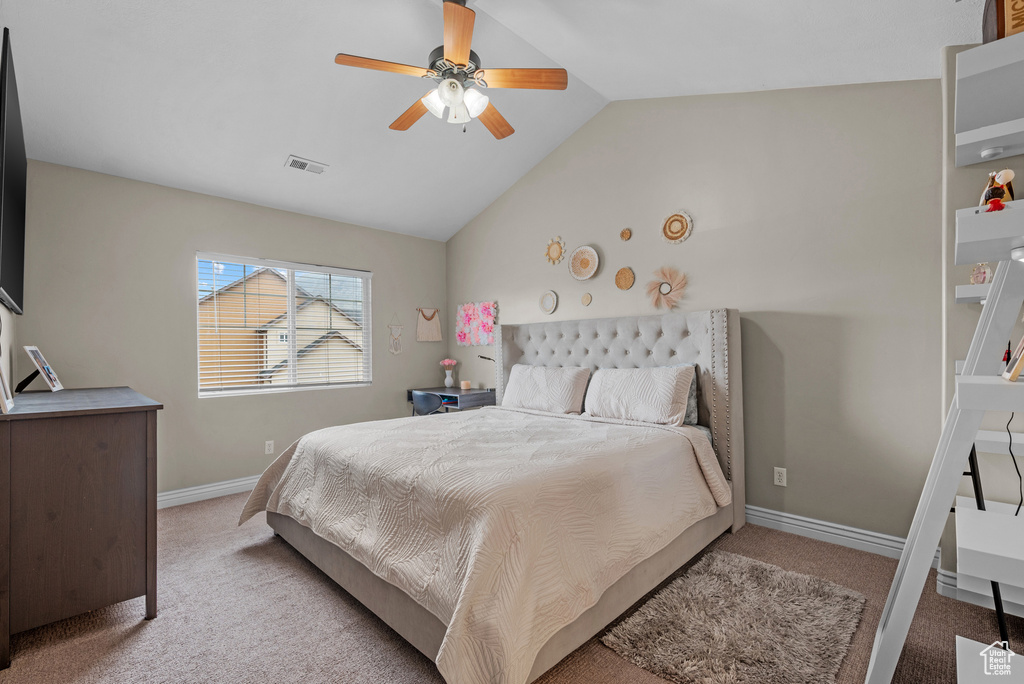 Bedroom with light carpet, vaulted ceiling, baseboards, and a ceiling fan