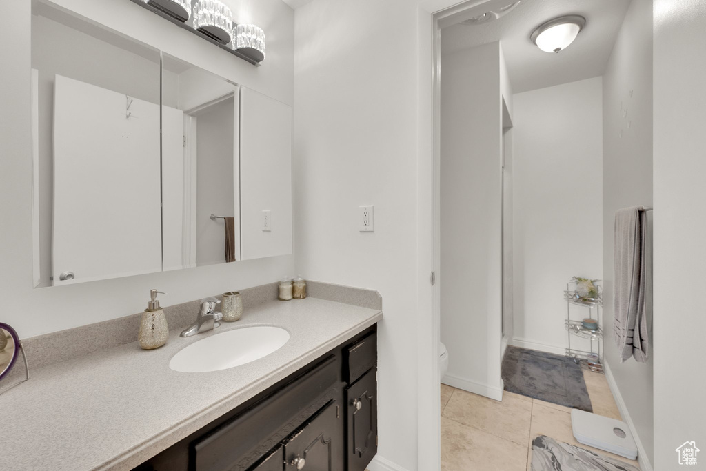 Bathroom with tile patterned flooring, vanity, and toilet