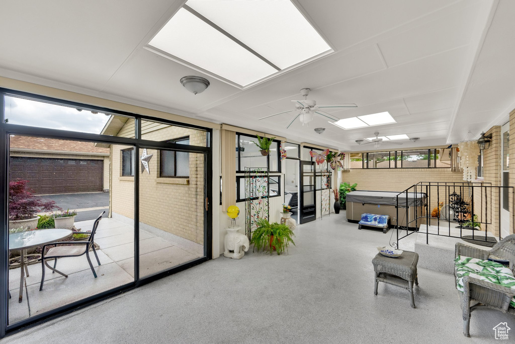 Sunroom / solarium featuring a hot tub, a skylight, and a ceiling fan