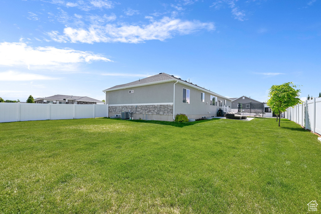 Back of property featuring stone siding, stucco siding, and central AC unit