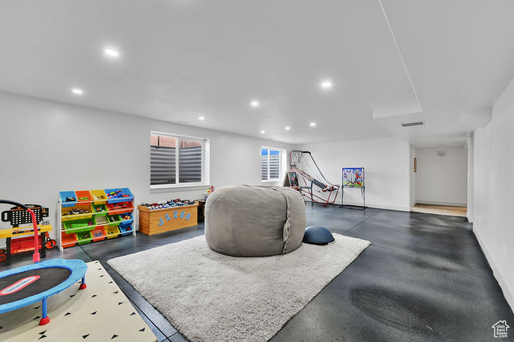 Rec room with recessed lighting, baseboards, and finished concrete flooring