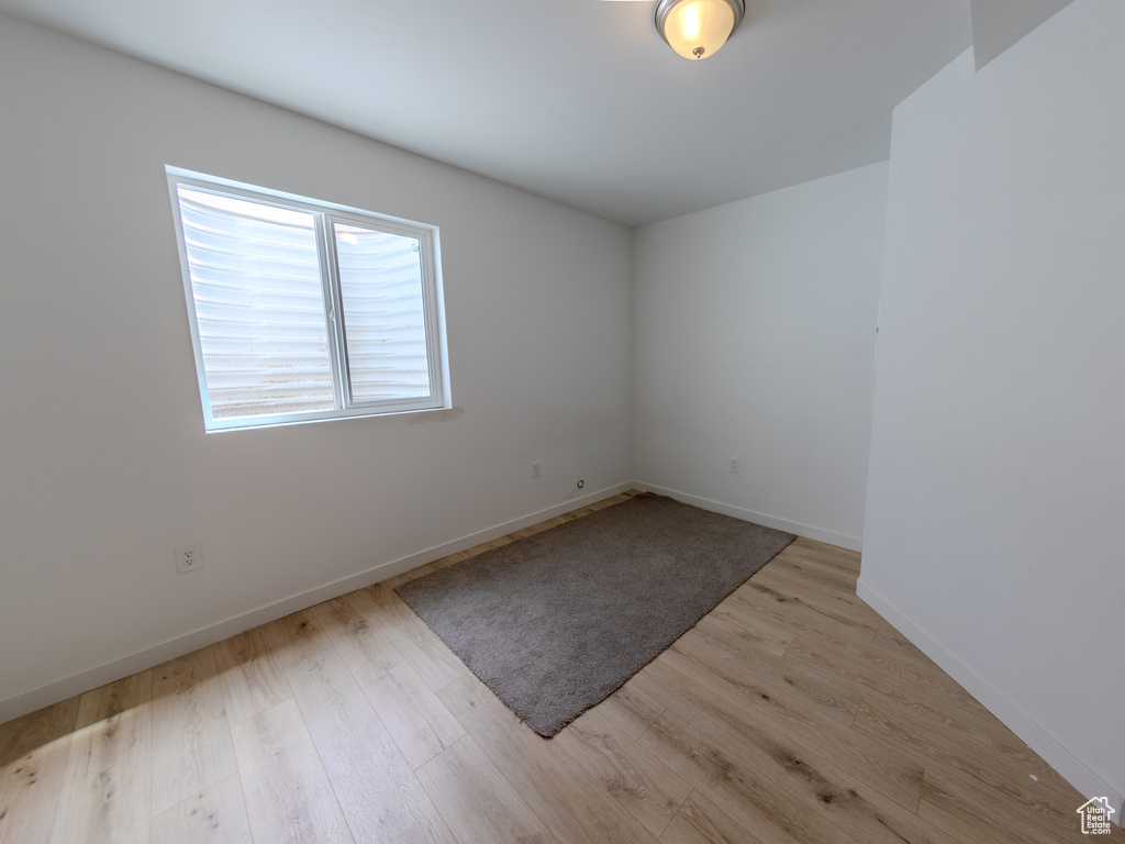 Empty room with light wood-style flooring and baseboards