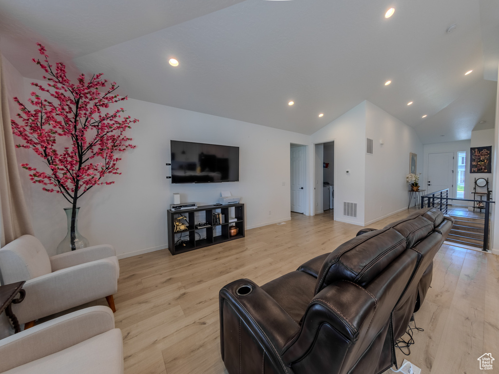 Living room featuring light wood-style floors, vaulted ceiling, recessed lighting, and baseboards