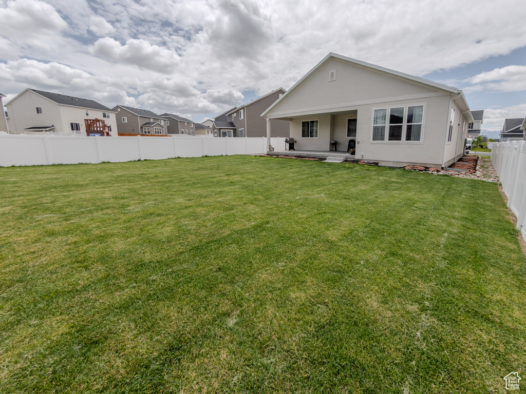 Rear view of house with stucco siding and a patio area