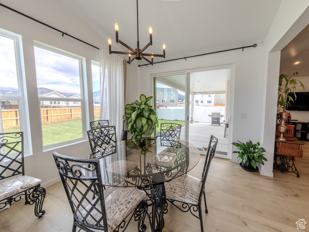 Dining area featuring a chandelier, light wood-type flooring, and baseboards