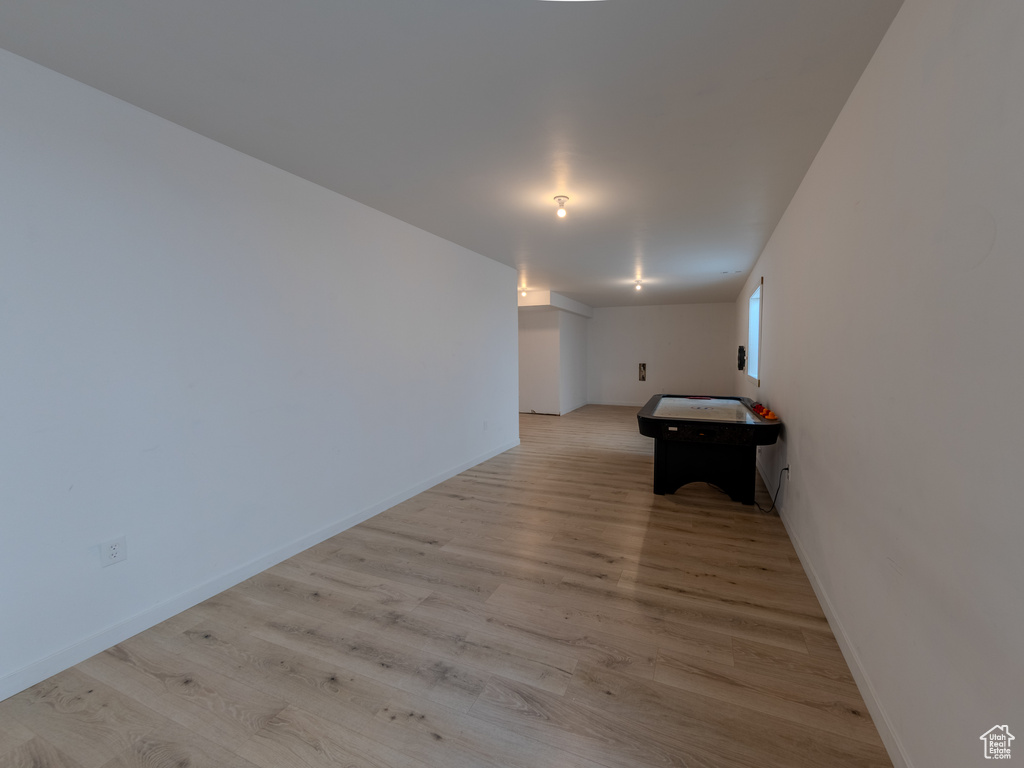 Corridor with light wood-style flooring and baseboards