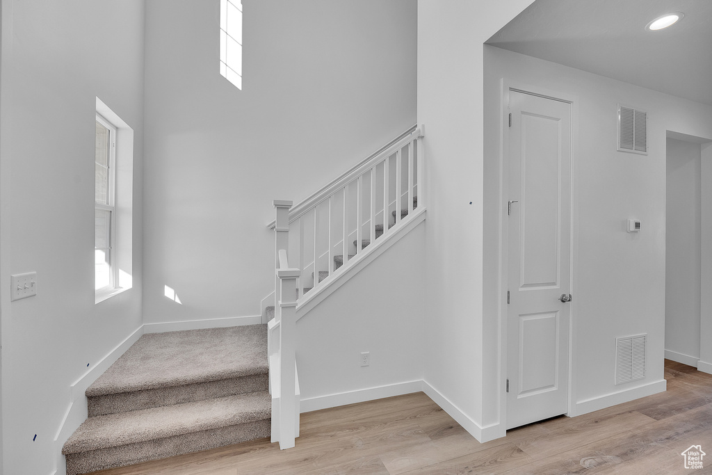 Staircase with baseboards and wood finished floors