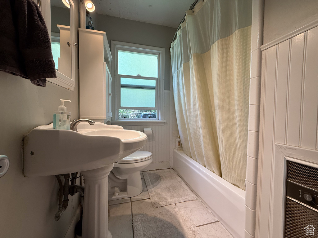 Bathroom with toilet and shower / bath combo with shower curtain