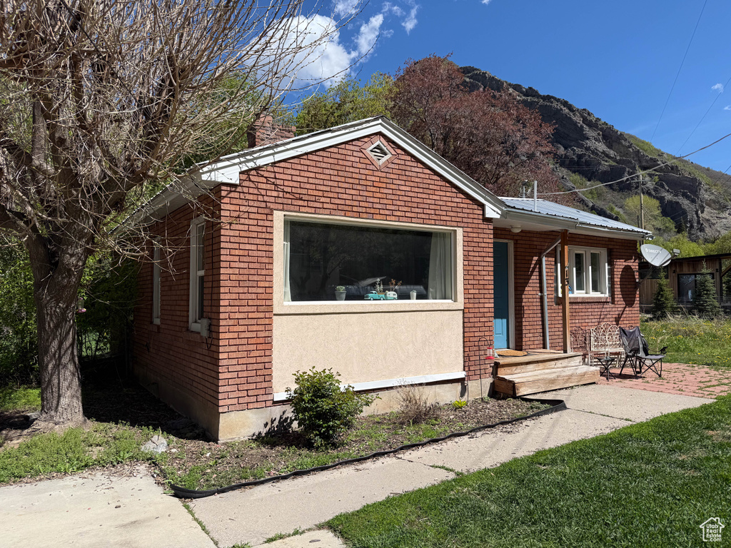 Bungalow-style home with a mountain view, brick siding, and a chimney