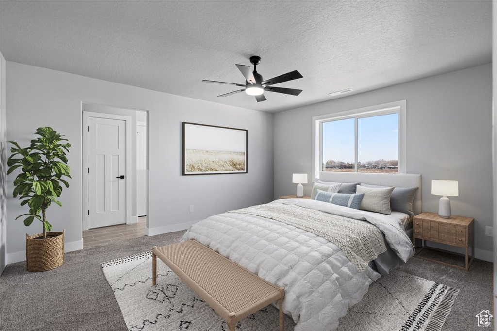 Bedroom with carpet flooring, baseboards, ceiling fan, and a textured ceiling