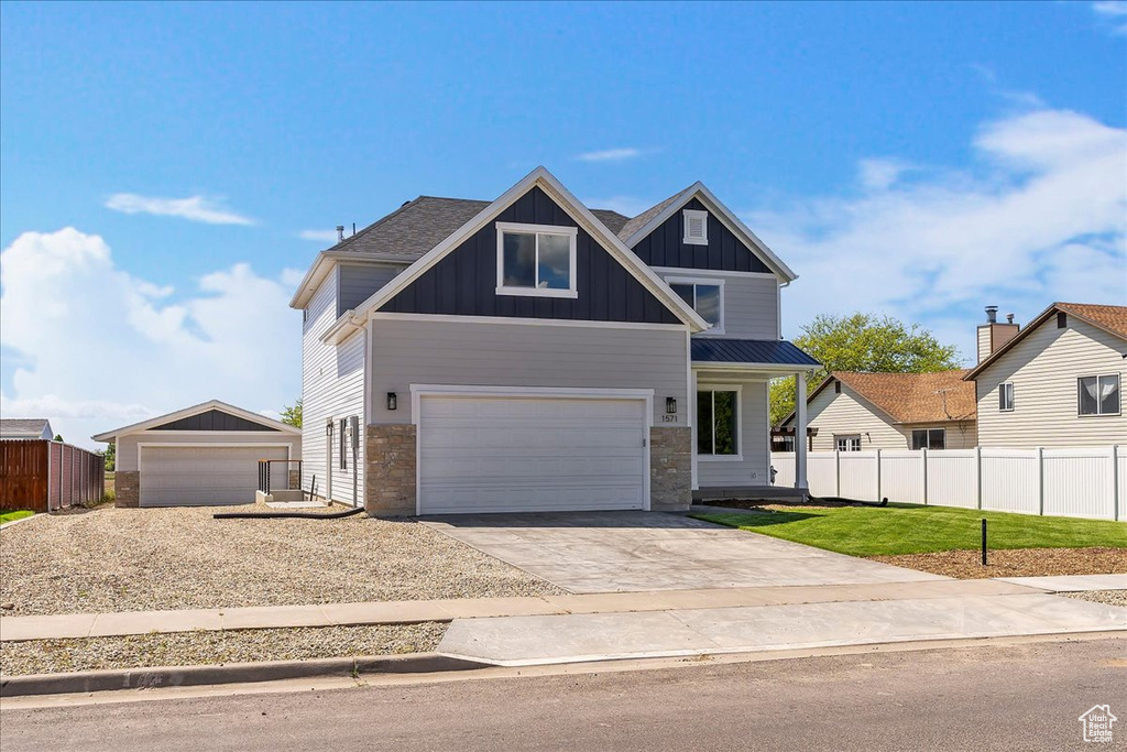 Craftsman-style home with board and batten siding, concrete driveway, stone siding, and a garage