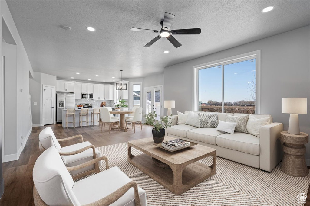 Living area featuring recessed lighting, ceiling fan, dark wood-style flooring, baseboards, and a textured ceiling
