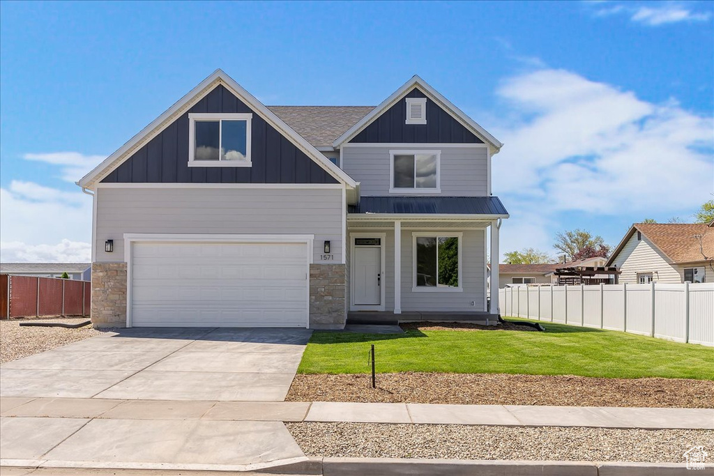 Craftsman house with driveway, stone siding, board and batten siding, and a garage