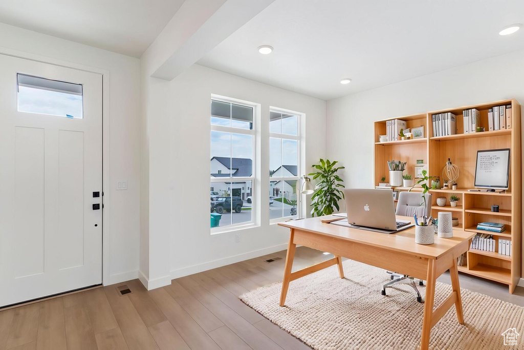 Office space with healthy amount of natural light, light wood-type flooring, baseboards, and recessed lighting