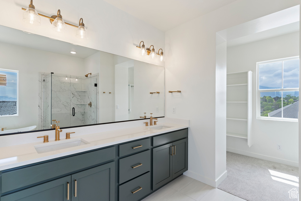 Full bathroom featuring a marble finish shower, baseboards, double vanity, and tile patterned flooring