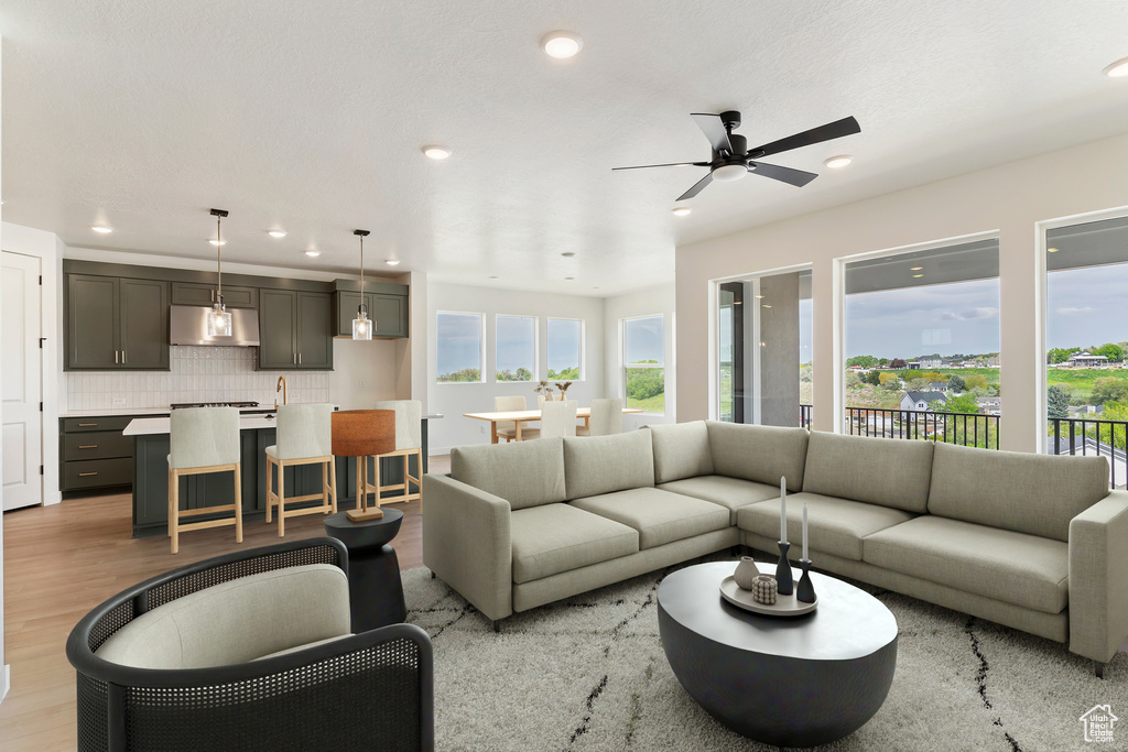 Living area featuring ceiling fan, light wood-style floors, and recessed lighting