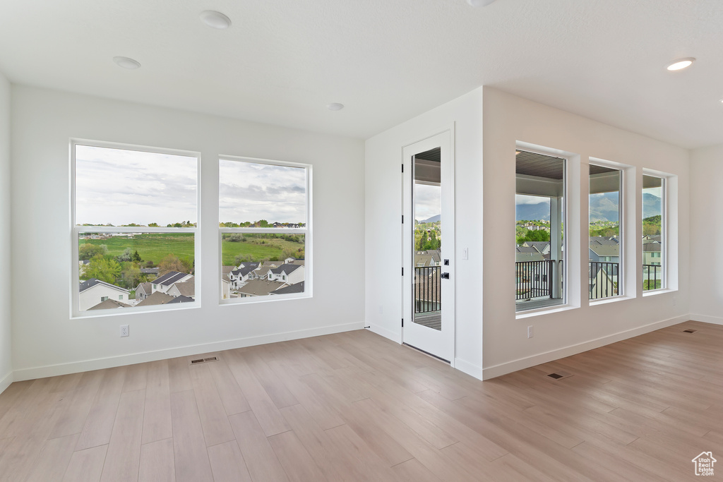 Spare room featuring light wood finished floors, baseboards, and recessed lighting