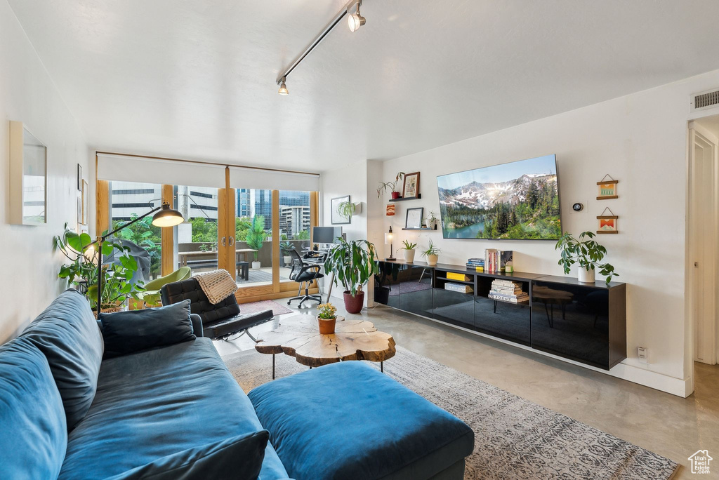 Living room with finished concrete floors and rail lighting