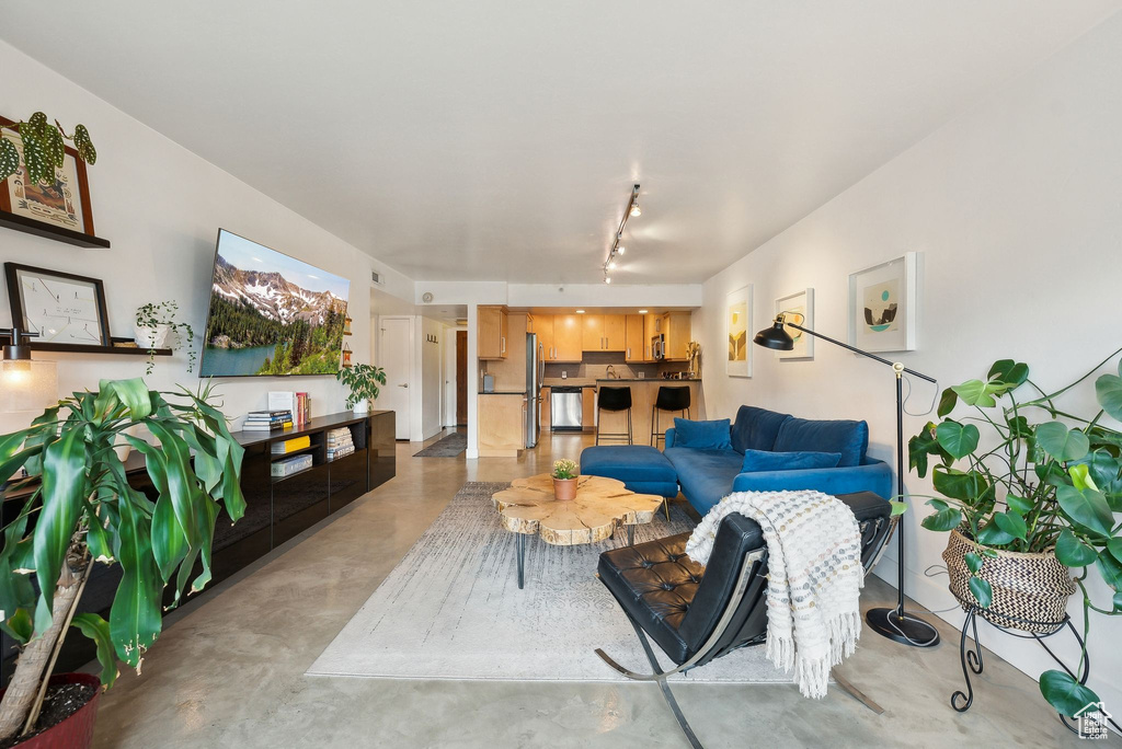 Living area featuring finished concrete floors and rail lighting