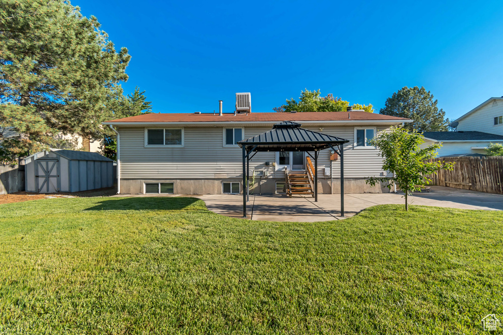 Back of property with a gazebo, a patio, and central AC