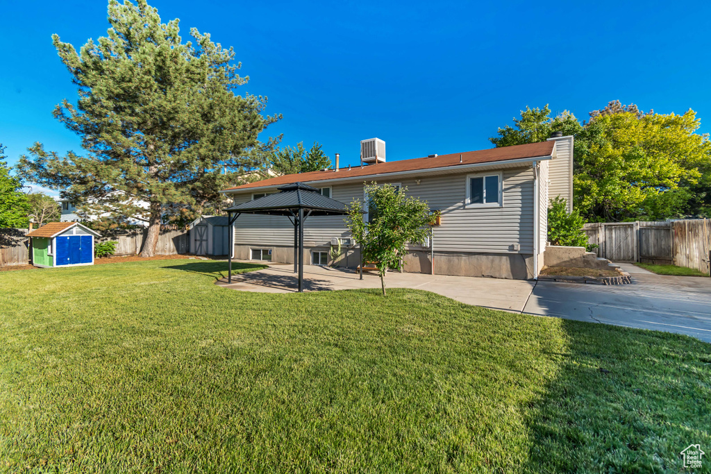 Back of house featuring a patio, a gazebo, and a chimney