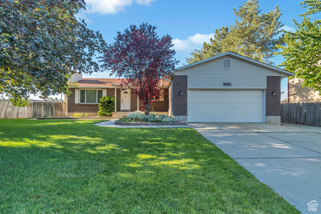 Single story home featuring brick siding, a garage, concrete driveway, and a chimney