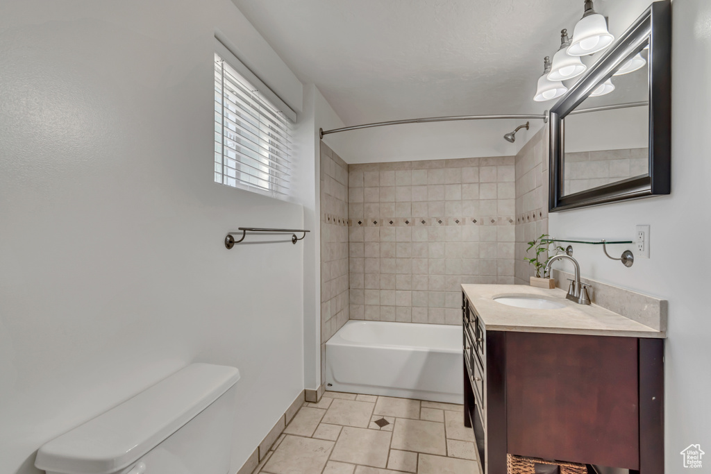 Full bath with shower / tub combination, vanity, toilet, baseboards, and tile patterned flooring